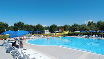 Una piscina al aire libre de temporada, sombrillas, tumbonas