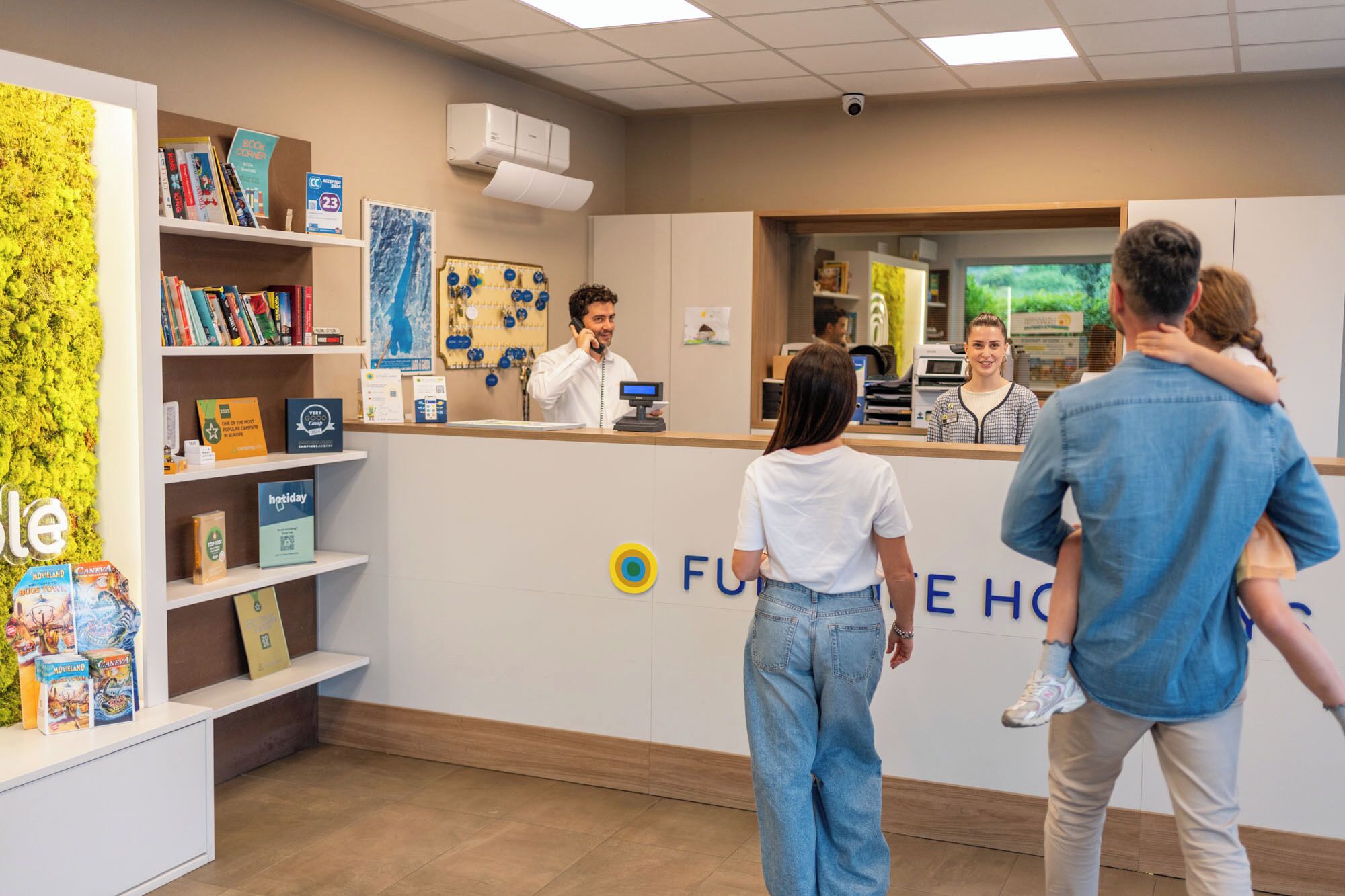 A reception desk with a 'FUTURE HOME' sign, a counter, and a person behind it.