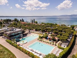 Un resort con una grande piscina, uno scivolo acquatico e vista sul mare.