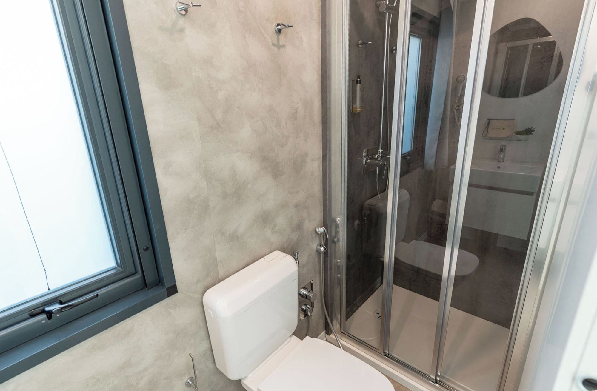 A bathroom with a toilet, a shower enclosure, and a glass door.