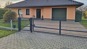 Ein eingeschossiges Haus mit Ziegeldach, einer Haustür und einer Garage.