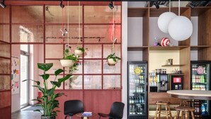 Ein modernes Interieur mit Barbereich, Sitzgelegenheiten und hängenden Pflanzen.