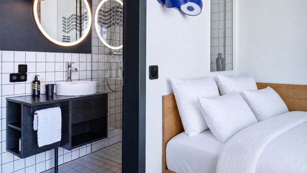 Ein modernes Badezimmer mit Waschbecken, Spiegel und Handtuchhalter.