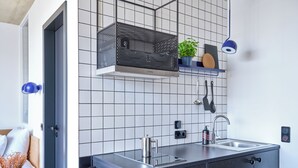 Eine moderne Küche mit doppelter Spüle, Edelstahlgeräten und einer Spritzschutzwand mit Rasteroptik.