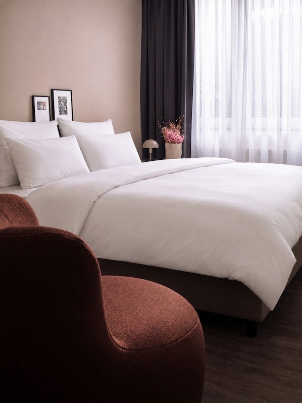 A hotel room with a large bed, a nightstand, a lamp, and a framed picture on the wall. - STAYERY Cologne Sülz (Cologne)