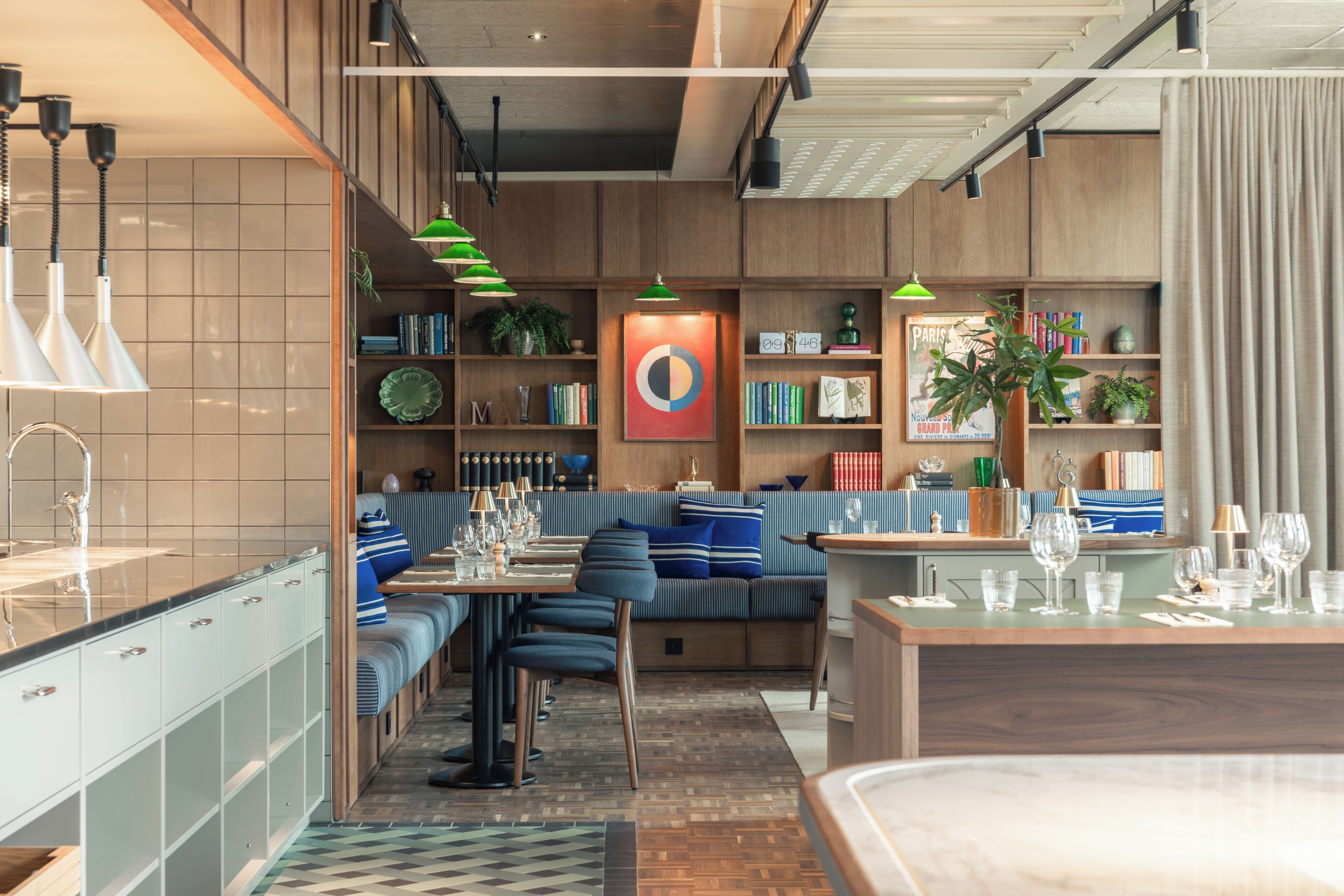 Un restaurante moderno con barra, zona de estar y cocina a la vista.