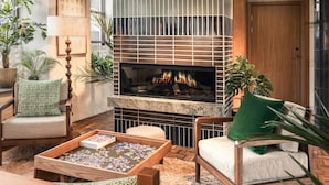 Una sala de estar acogedora con chimenea, asientos cómodos y una mesa para rompecabezas.