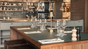 Una cocina moderna con una isla central, electrodomésticos de acero inoxidable e iluminación colgante.