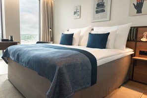 A hotel room with a large bed, a bedside table, a nightstand, and a view of the outdoors. - Quality Hotel The Book (Gothenburg)