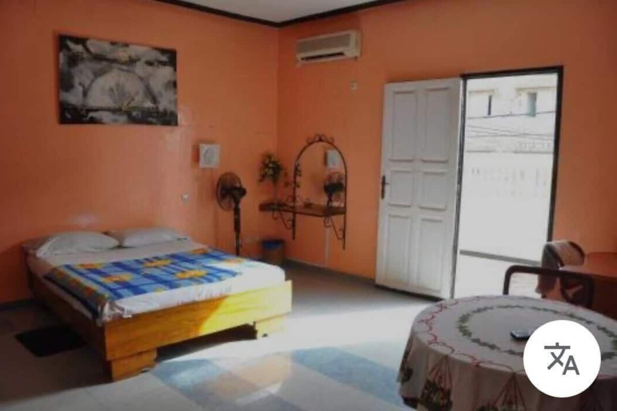 Un dormitorio con una cama, una mesa y una puerta que da a un balcón.