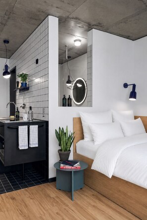A modern bedroom with a bed, bedside table, and a small potted plant. - STAYERY Berlin Friedrichshain (Berlin)