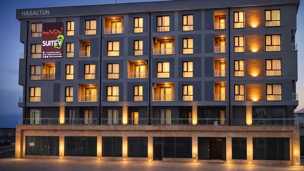 A modern hotel with multiple floors, balconies, and illuminated windows. - Suitev (Arnavutkoy)