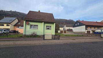 Ein Wohngebiet mit Häusern, einer gepflasterten Straße und einem Zaun.