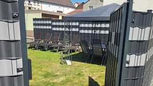 A gated outdoor area with a covered seating area and a grassy lawn. - Vacation home Lautertal-Lodge with private pool/whirlpool for up to 10 people (Kreimbach-Kaulbach)