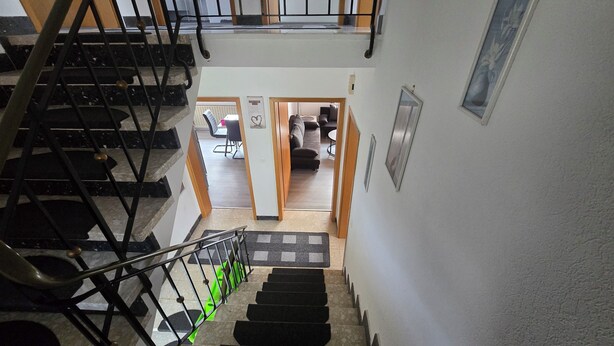A staircase with black railings and a green mat at the bottom. - Vacation home Lautertal-Lodge with private pool/whirlpool for up to 10 people (Kreimbach-Kaulbach)