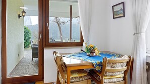 A dining area with a table, chairs, a window, and a view of the outdoors. - Apartment Josef with Private Terrace (Radolfzell am Bodensee)