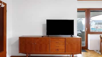 Ein Holzschrank mit einem Flachbildfernseher, einer Tür und einem Fenster mit Blick.