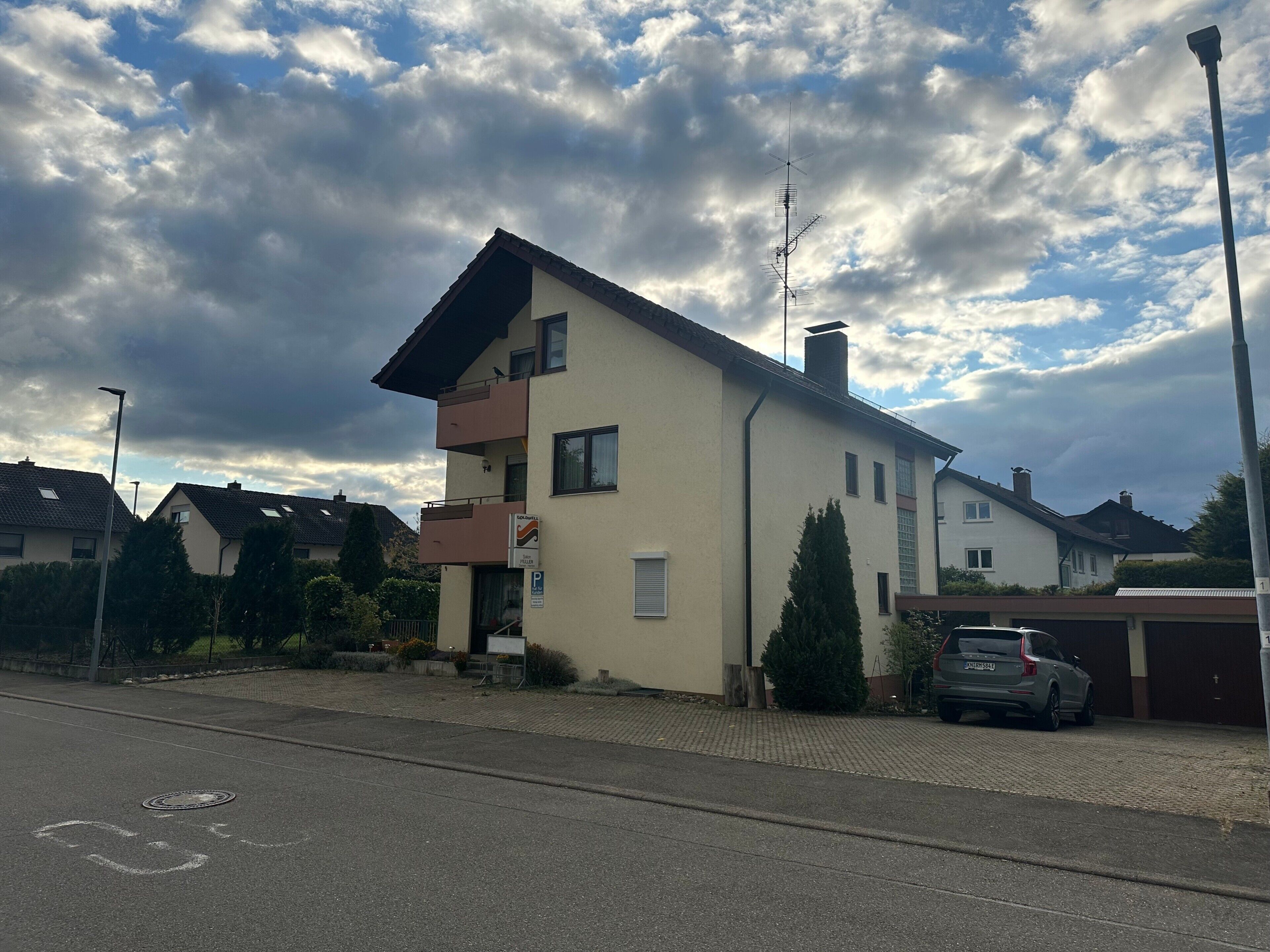 Un immeuble résidentiel de deux étages, doté d’un toit plat, d’une cheminée et d’une antenne parabolique visible.