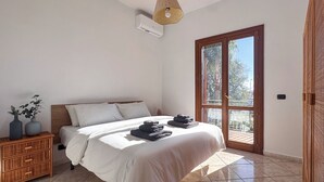 Une chambre à coucher avec un lit, une table de chevet, une fenêtre et une porte.