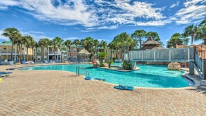 A swimming pool with lounge chairs and palm trees. - Family Friendly & Resort Perks! Perdido Key Condo (Pensacola)