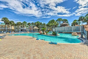 Ein Swimmingpool mit Liegestühlen und Palmen.