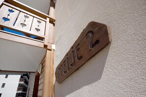 Ein Holzschild mit der Nummer 2 an einer Hauswand.