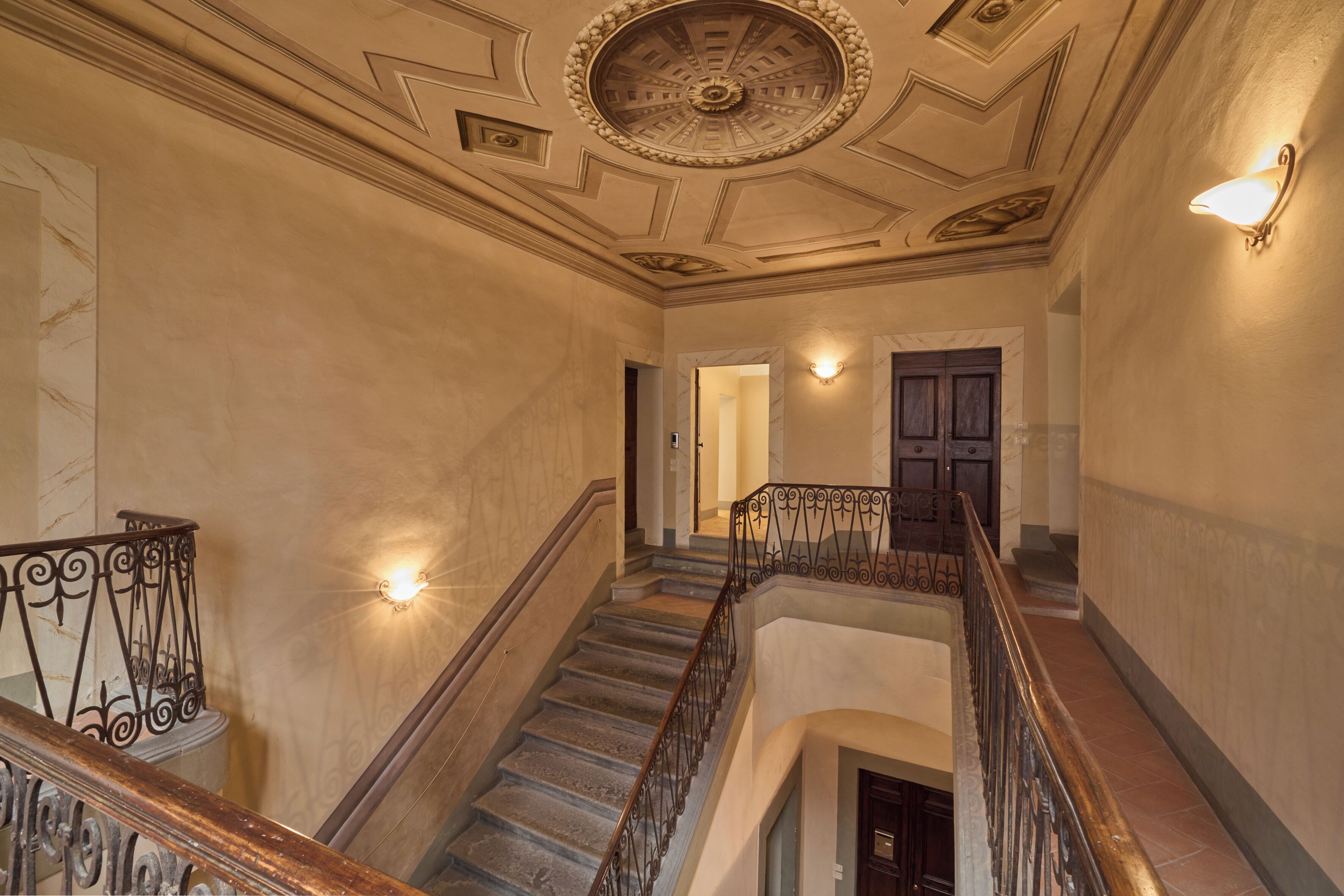A grand staircase with ornate railings and a decorative ceiling.