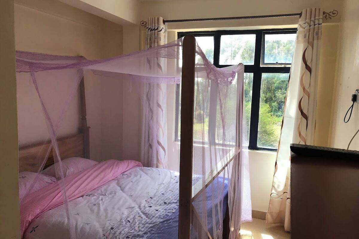 A room with a bed, a window, and a desk.