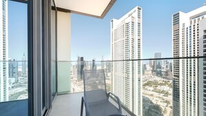 A balcony with a chair and table, offering a city view. - StayShort - 2 Bed in Downtown Dubai that Sleeps 4 with Canal Views! (Downtown)