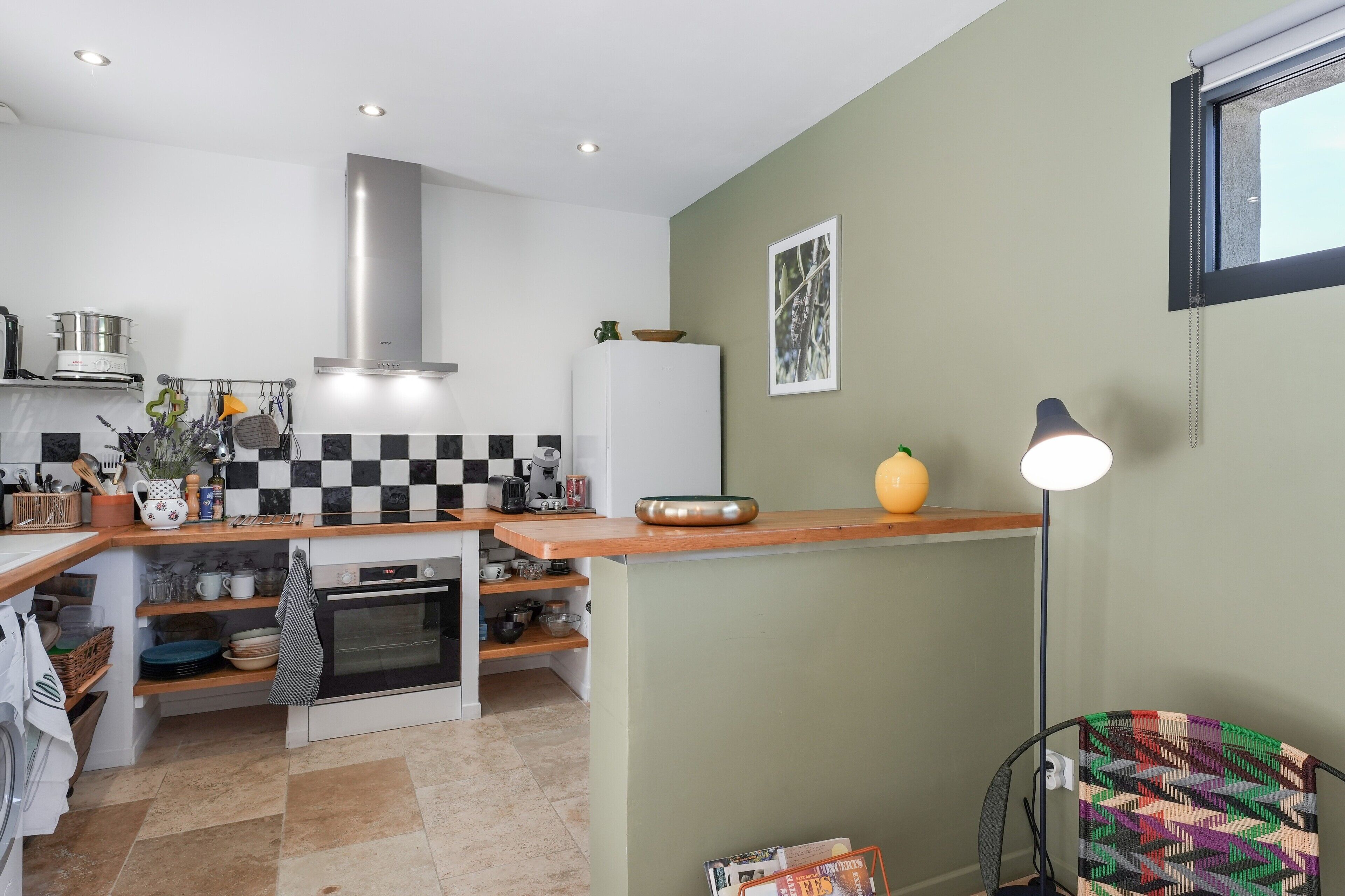 Une cuisine moderne équipée d’une cuisinière, d’un four et de meubles blancs.