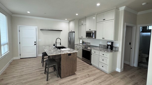 A modern kitchen with white cabinets, a granite countertop, and stainless steel appliances. - Fabulous 2-bedroom house with private boat ramp access to the Sacramento River (Redding)