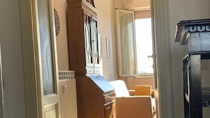A hallway with a wooden cabinet, a white door, and a bed with a yellow pillow. - Apartment with panoramic view - Holiday Home Giulia (Roma)