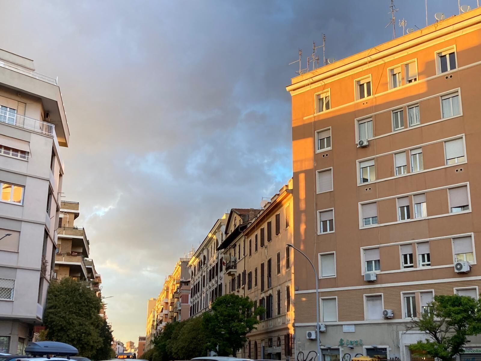 Una hilera de edificios de varios pisos con balcones y unidades de aire acondicionado, con una calle en medio.