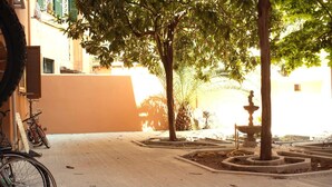 A courtyard with a fountain, trees, and a bicycle. - Apartment with panoramic view - Holiday Home Giulia (Roma)