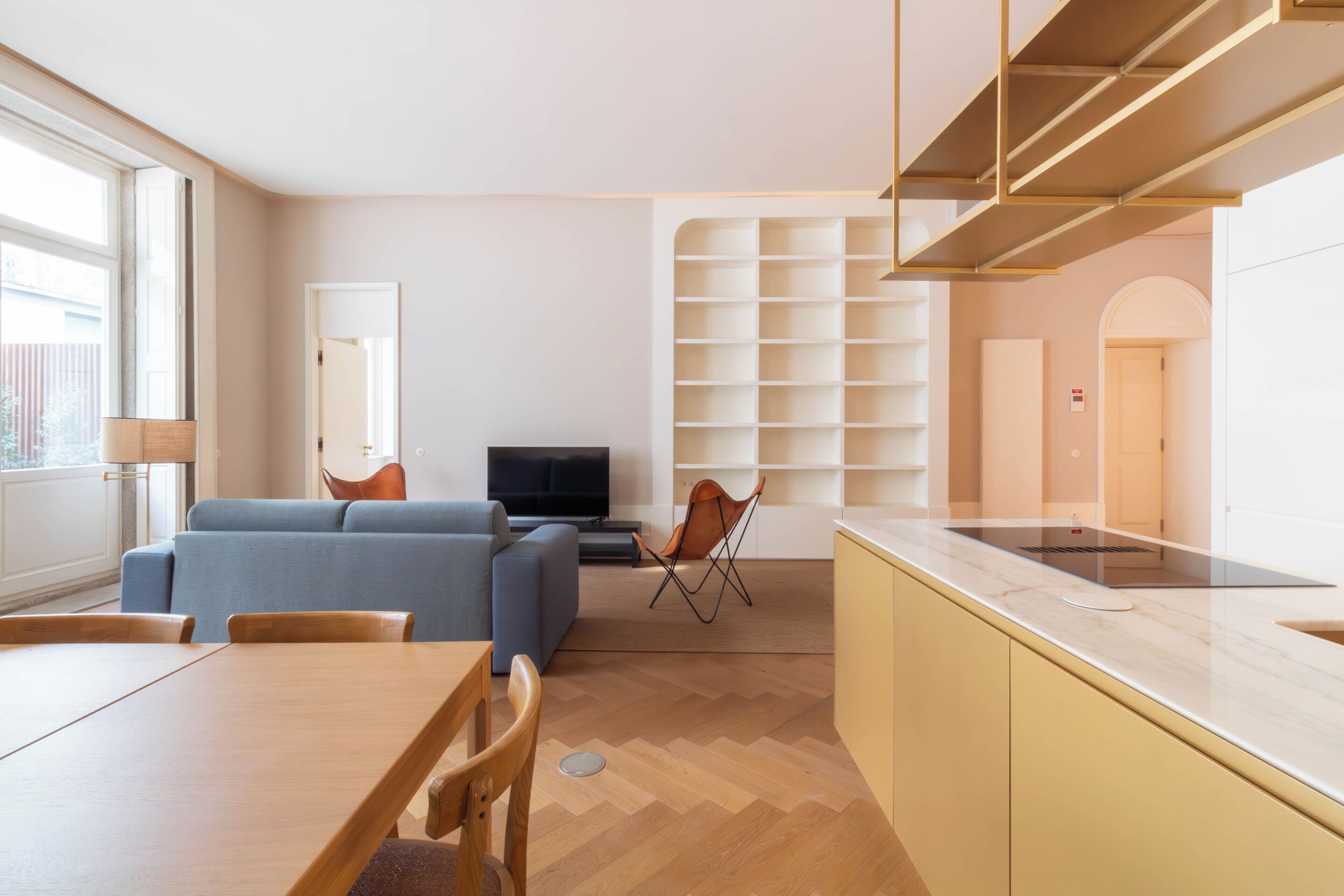 Un salon moderne comprenant un canapé, un téléviseur et un coin repas avec une table et des chaises.