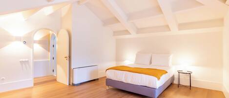 A modern bedroom with a bed, a small bedside table, and a wardrobe.