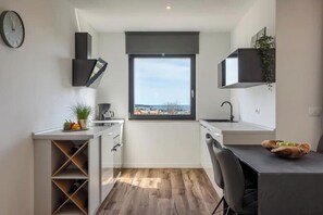 Eine moderne Küche mit Aussicht, inklusive Weinkühlschrank und Essbereich.