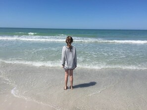 A person standing on a beach with the ocean in the background. - Across the street from Indian Shores Beach Condo (Indian Shores)