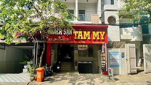 Un hôtel appelé « KIM CHAOQJY KACH », avec un auvent rouge et une enseigne.
