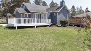 A two-story house with a covered front porch and a small deck. - The Little Blue Inn (Rochester)