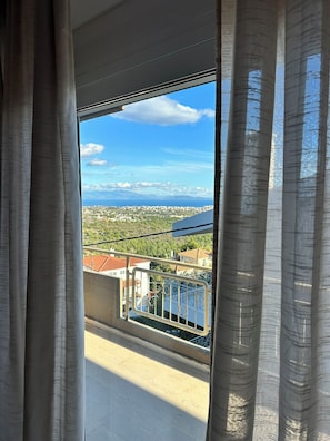 A balcony with a view of a coastal cityscape, including buildings and a body of water. - Aegean Hill Skyview (Rafina)