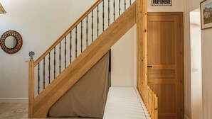 Una escalera con barandillas de madera y alfombra color beige.