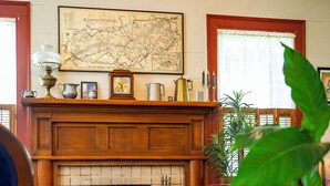 Un salon chaleureux avec une cheminée, une carte accrochée au mur et divers objets décoratifs.