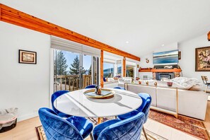 A modern living room with a round dining table, blue chairs, a white sofa, and a fireplace. - Lakeview Incline Village Gem | Near Beach & Ski (Incline Village)