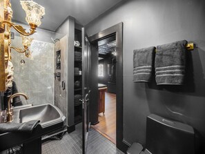 Ein modernes Badezimmer mit einer gläsernen Duschkabine, einer freistehenden Badewanne und einem Waschtisch mit Spiegel.