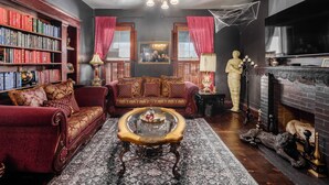 A cozy living room with a fireplace, a bookshelf, and a statue.