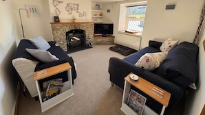 A cozy living room with two sofas, a fireplace, a television, and a window with a view. - Arcadia - 2-Bed, Dog Friendly with EV Charger (Mere)