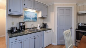A kitchen with white cabinets, a coffee maker, a toaster, and a dishwasher. - Lower Unit  Killington Ski Stay w/ Fireplace & EV Charger (Killington)