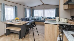 Cocina funcional con estufa, mesa de comedor con sillas y un banco empotrado con cojines.