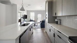 Een moderne keuken met een groot eiland, roestvrijstalen apparatuur en een minimalistisch design.